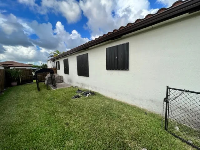 Black accordion shutters on side elevation